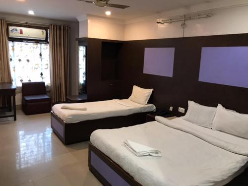 古瓦哈提HOTEL SHIVA的酒店客房,配有两张床和椅子