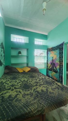 布什格尔ANAND HOSTEL的一间卧室配有一张带蓝色墙壁的大床