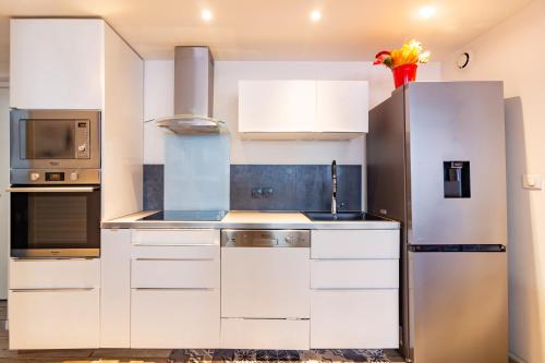 图卢兹Appartement T4 central quartier Saint-Georges -Le Picomax-的厨房配有白色橱柜和不锈钢冰箱