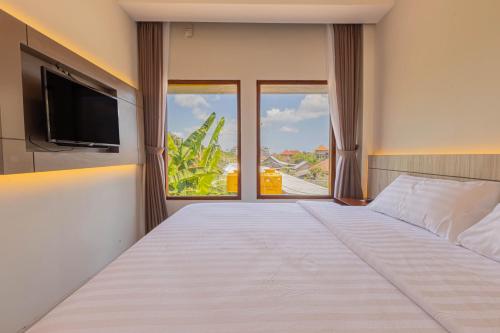 金巴兰The Baliem Hotel的卧室设有一张白色大床和大窗户