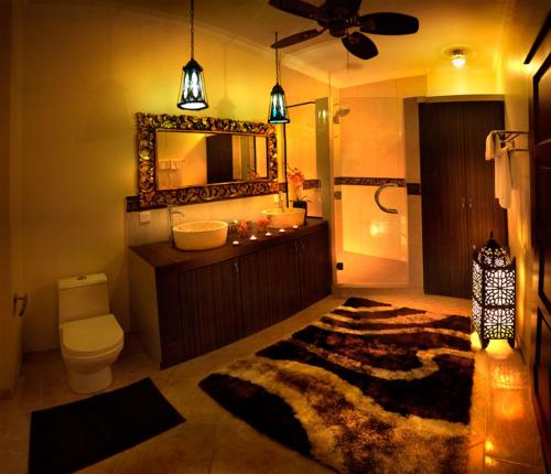 瑟古邦坦帕瑟南Spa餐饮度假酒店的浴室配有盥洗池、卫生间和镜子。