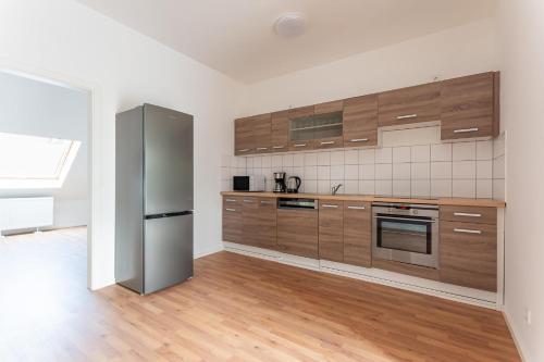 杜伊斯堡T&K Apartments - DUISBURG - Frisch renovierte 4 Zimmer Maisonetten mit Privatparkplätzen的厨房配有木制橱柜和不锈钢冰箱。