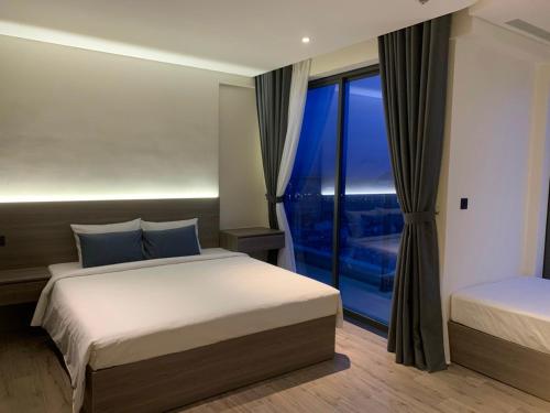 绥和市Apec Mandala Phú Yên的一间卧室设有两张床和大窗户