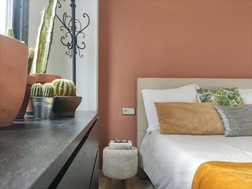 贝尼多姆Refugio Racó del Conill - Mountain, Beach & Spa的一间卧室拥有橙色的墙壁,配有一张床和仙人掌