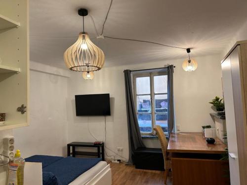 特里尔Trier City Center Apartments Altstadt的一间卧室配有一张床、一张书桌和一个窗户。