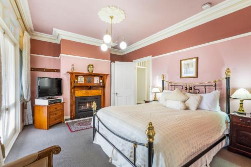 卢拉Bethany Manor B&B call them for Guaranteed Cheapest Price的一间卧室配有一张床和一个壁炉