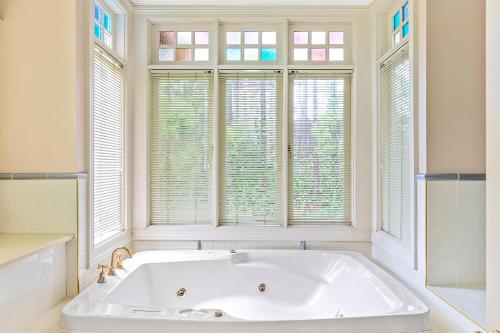 卢拉Bethany Manor B&B call them for Guaranteed Cheapest Price的带窗户的浴室内的白色浴缸