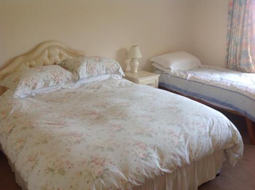 金斯布里奇Estuary View Farm的一间卧室配有一张带花卉棉被的床