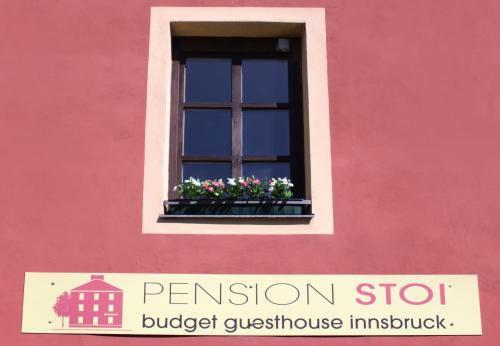 因斯布鲁克斯托伊经济型酒店的粉红色的建筑,窗户上放着鲜花
