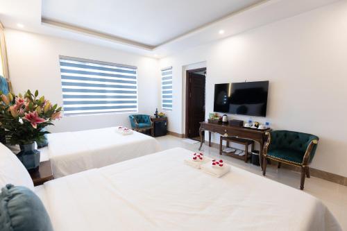 河内Royal Hotel Sài Đồng - Long Biên的一间带两张床和电视的客厅