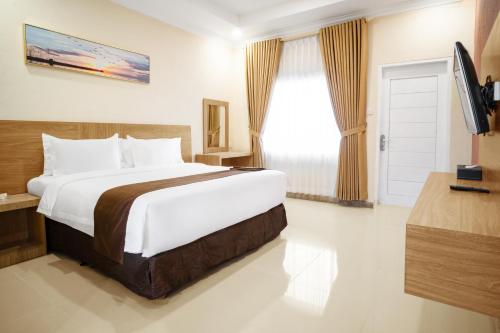 特鲁克巴库Agro Hotel Bintan的酒店客房设有一张大床和一台电视。