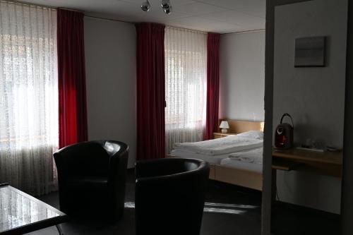 赛尼厄莱吉耶Hôtel de la Gare的酒店客房,配有一张床和两把椅子