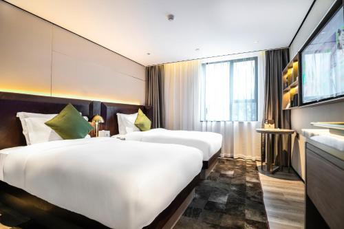 广州宜尚Plus酒店广州北京路步行街店的酒店客房设有两张床和电视。