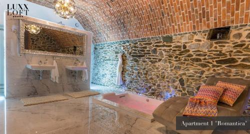韦茨拉尔LUXXLOFT Luxusapartments Wetzlar的带浴缸和水槽的石质浴室