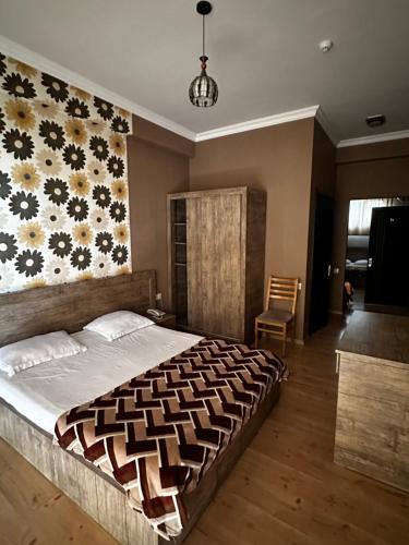 第比利斯Hotel Nirvana的一间卧室设有一张带花卉墙壁的大床