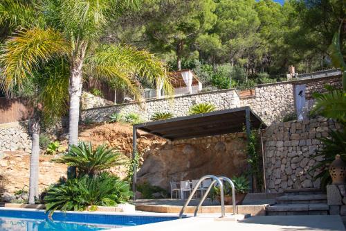 凯玛丽Villa Can Rasca的一个带游泳池和棕榈树的度假村