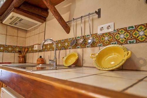 丰特埃里多斯Tragaluz I的厨房柜台设有水槽和黄色碗