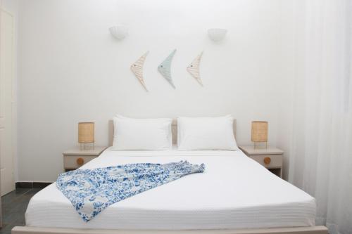 洛加拉斯Aura Paros的白色的床和蓝色和白色的毯子