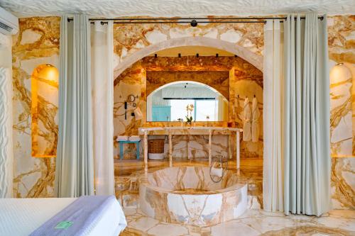 Tzamaria阿加利亚豪华套房别墅的一间位于客房中间的带浴缸的浴室