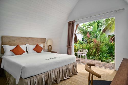 高龙撒冷岛Eden Beach Resort by EHM的一间卧室设有一张床和一个大窗户