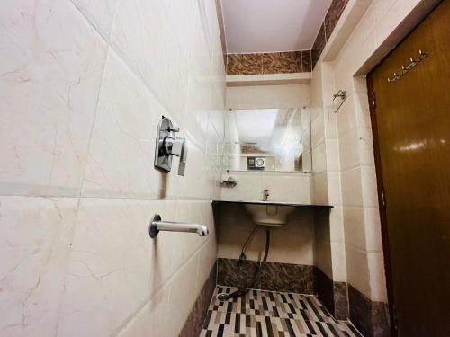 巴特那Hotel Mani International的一间带卫生间的浴室和墙上的一部电话