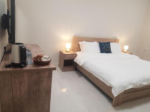 Abyār ‘Alīمورايا Murraya的一间卧室配有一张床、一台电视和两盏灯。
