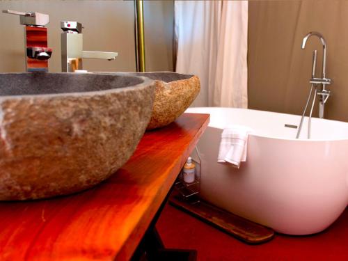 圣皮埃尔Gadiamb City的浴室配有大型石质水槽和浴缸。