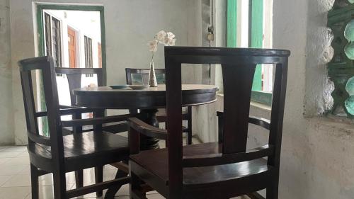 LewolebaHotel Rejeki的餐桌、两把椅子、一张桌子和椅子