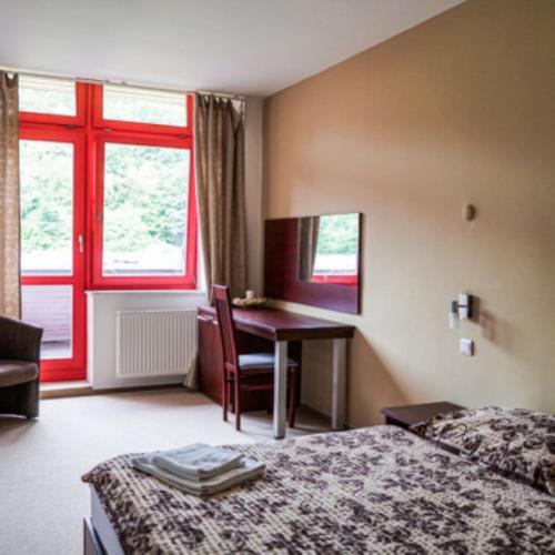 奥帕瓦Hotel Belaria Resort的配有一张床、一张书桌和一扇窗户的酒店客房