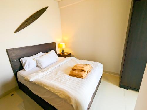 巴淡岛中心Lovina 27-AB at One Residence(near Ferry & Megamall)的一间卧室,床上有棕色的袋子