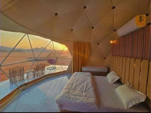 瓦迪拉姆RUM EiLEEN LUXURY CAMP的一间带沙发床的卧室,享有沙漠美景
