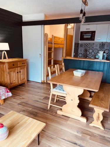 奥尔西埃Magnifique studio 4 pers avec balcon vue montagne的一间带木桌的客厅和一间厨房