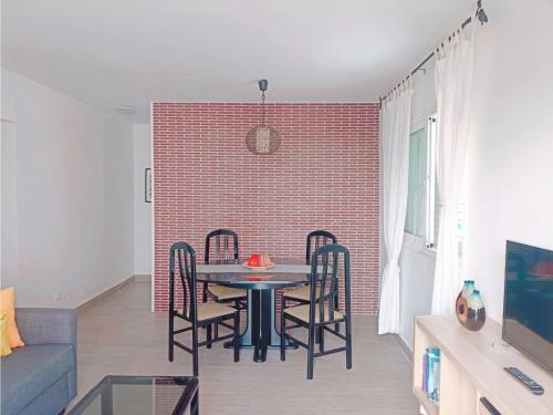拉拉古纳Live La Laguna Gracia的一间设有桌椅和砖墙的用餐室