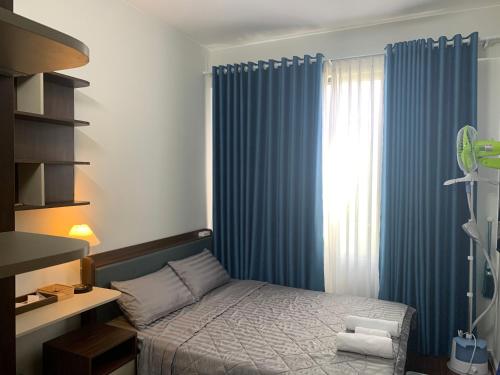 胡志明市BIN’S HOUSE的一间卧室配有一张床和蓝色窗帘