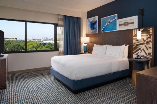奥兰多奥兰多迪斯尼泉希尔顿逸林套房酒店的酒店客房设有一张床和一个大窗户