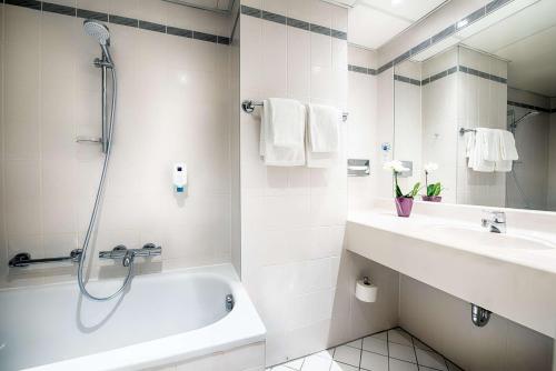开姆尼茨Congress Hotel Chemnitz的带淋浴、盥洗盆和浴缸的浴室