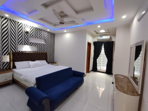 伊斯兰堡Luxury Holiday Home in Islamabad的一间卧室配有一张床和蓝色的灯光