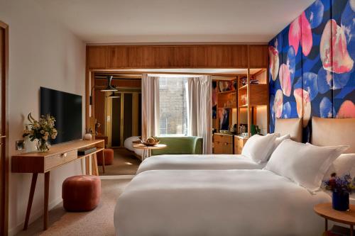 伦敦The BoTree - Preferred Hotels and Resorts的酒店客房设有两张床和电视。