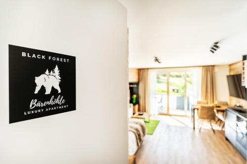 施卢赫湖Black Forest Luxury Apartment Bärenhöhle mit Sauna的一间客厅,门口设有黑森林标志