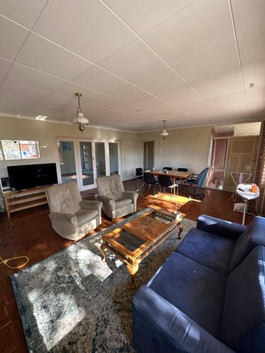 珀斯Chimu Home-Hostel的客厅配有蓝色的沙发和桌子
