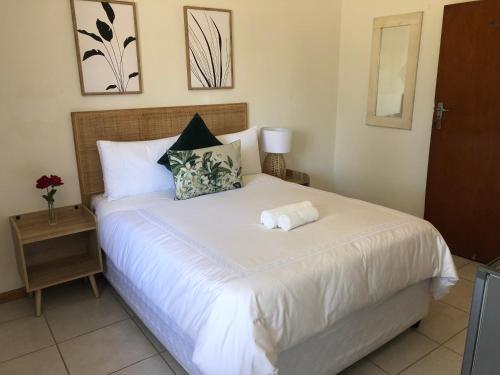 乌姆塔塔Bluebanana Lodge的一间卧室配有一张床,床上有毛巾