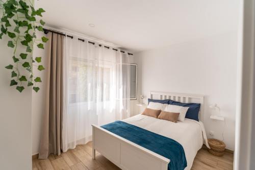 阿里纳加Sunny Winter Arinaga的白色的卧室设有床和窗户