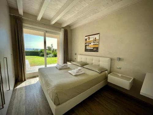 莫尼加La Giolosa Gardapartments的一间卧室设有一张大床和大窗户