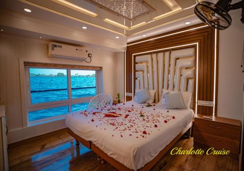 阿勒皮Charlotte Cruise House Boat的一间卧室配有一张大床,上面有红色玫瑰花瓣
