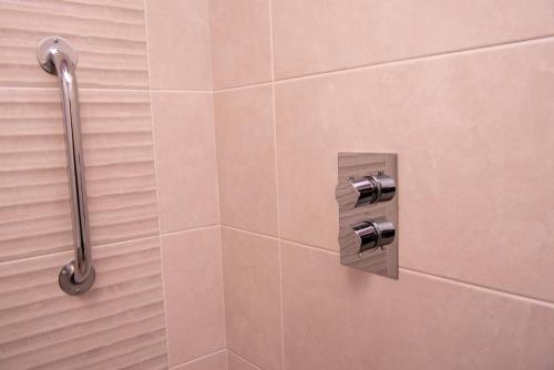 多尼戈尔Donegal House的带淋浴的浴室(带瓷砖墙)