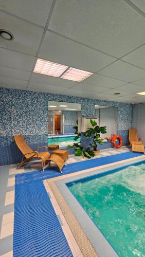 考纳斯考纳斯贝斯特巴提酒店的游泳池位于酒店带椅子的客房内,游泳池