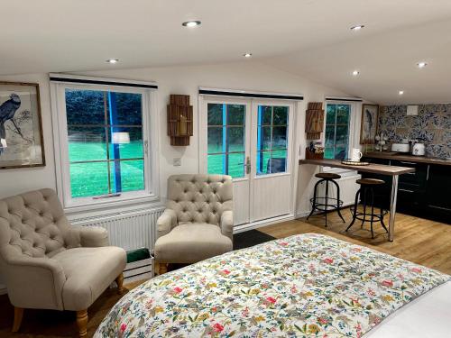 MayboleOak View Lodge: Cosy, Countryside Retreat的一间卧室配有一张床、两把椅子和一张桌子