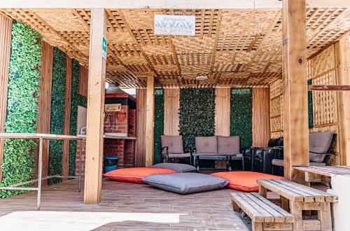 皮卡2 Cabañas para 5 Personas Oasis Pica-Matilla的带枕头、桌子和长凳的有盖庭院