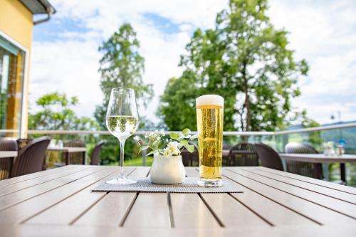 滨湖施图本贝格JUFA Hotel Garni Stubenberg am See的一张桌子,上面放着两杯啤酒和花瓶
