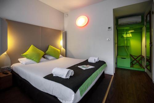 列日列日钟楼酒店的一间卧室配有一张绿色的大床